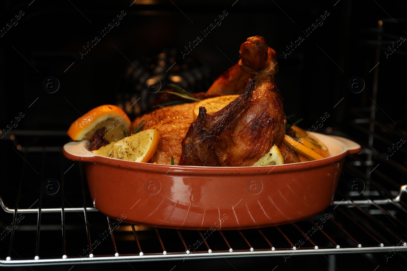 Photo of Chicken with orange slices baking in oven