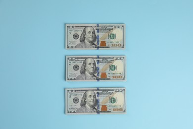 Photo of Money exchange. Dollar banknotes on light blue background, top view