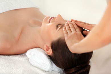 Photo of Beautiful young woman enjoying massage in spa salon