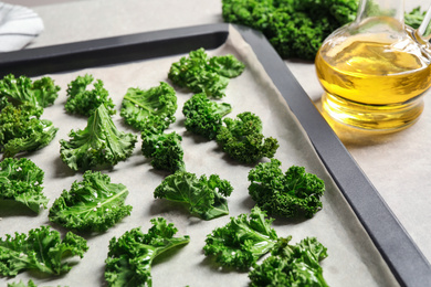 Raw cabbage leaves on baking sheet, closeup. Preparing kale chips