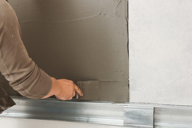 Photo of Worker installing tile in room, closeup. Home improvement