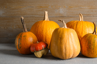 Photo of Many different ripe pumpkins on wooden table