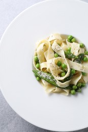 Photo of Delicious pasta with green peas on grey table, top view