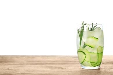Photo of Glass of refreshing cucumber lemonade and rosemary on wooden table against white background. Summer drink