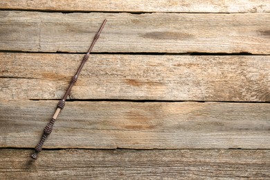 Photo of One old magic wand on wooden table, top view. Space for text