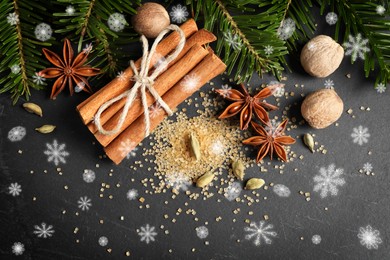 Image of Different spices and fir tree branches on dark table, flat lay. Cinnamon, anise, cardamom, nutmegs