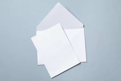 Photo of Letter envelope and card on grey background, top view. Space for text