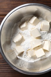 Making shortcrust pastry. Flour and butter in bowl on wooden table, top view