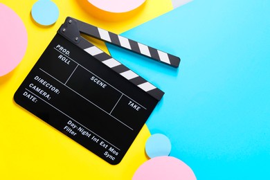 Photo of Clapperboard on color background, top view. Space for text