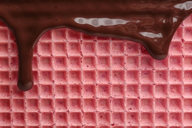 Hot dark chocolate on wafer, closeup. Crispy food