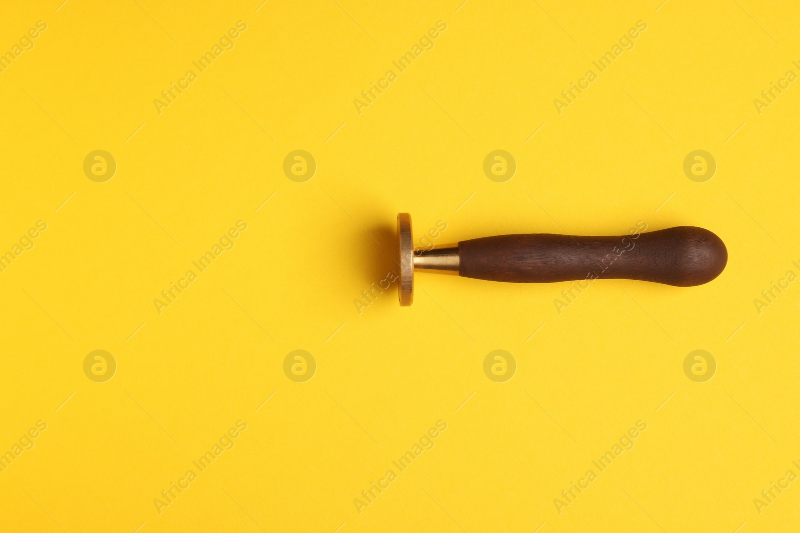 Photo of One stamp tool on yellow background, top view. Space for text