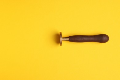 Photo of One stamp tool on yellow background, top view. Space for text