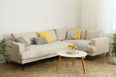 Stylish beige sofa in living room interior