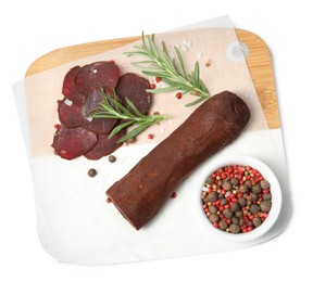 Photo of Delicious dry-cured beef basturma with rosemary and spices on white background, top view