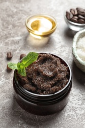 Photo of Jar with handmade natural body scrub and ingredients on grey background