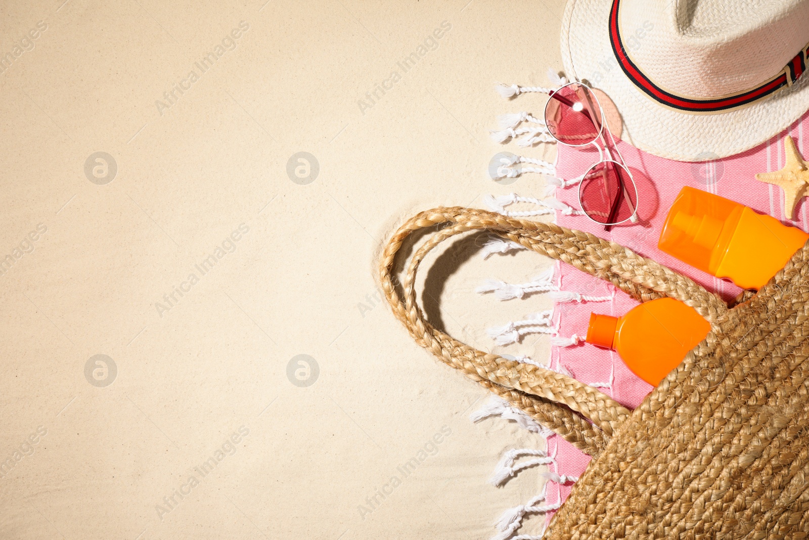 Photo of Composition with beach accessories and space for text on sand, flat lay