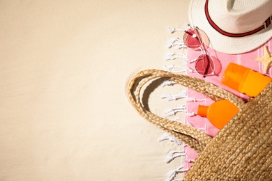 Photo of Composition with beach accessories and space for text on sand, flat lay