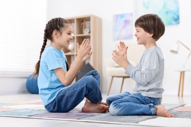 Happy brother and sister spending time together at home