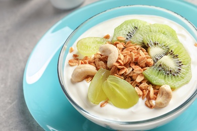 Photo of Bowl with yogurt, fruits and granola on table, closeup