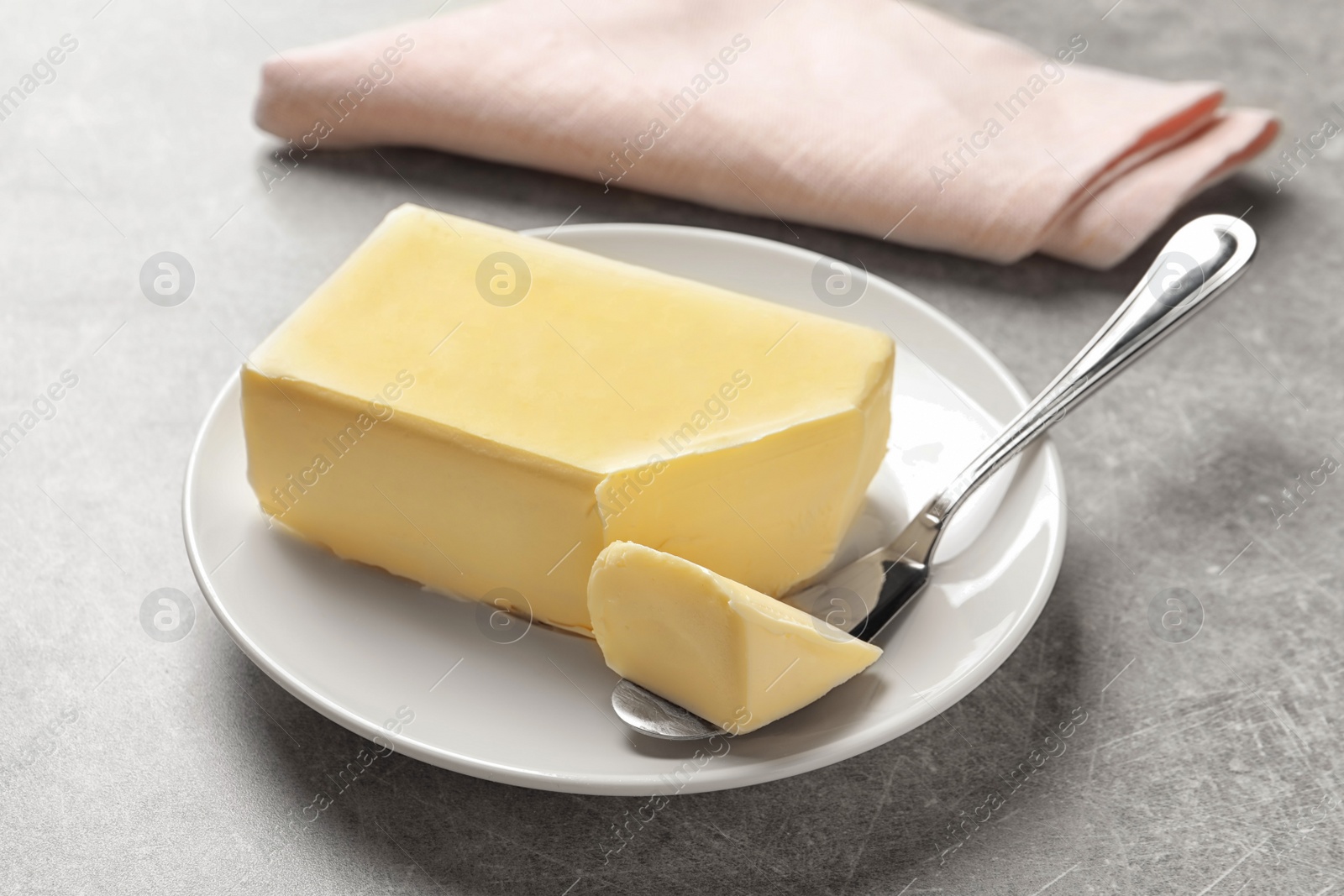 Photo of Plate with fresh butter and knife on table