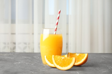 Glass with orange juice and fresh fruit on table