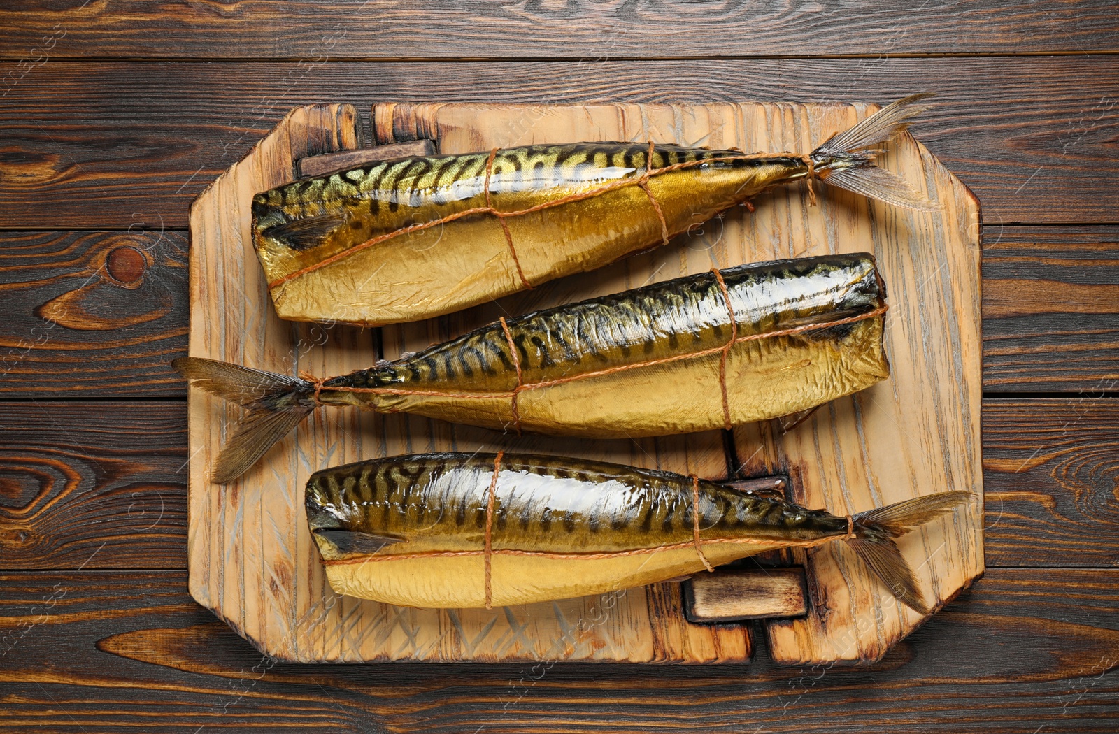 Photo of Tasty smoked fish on wooden table, top view