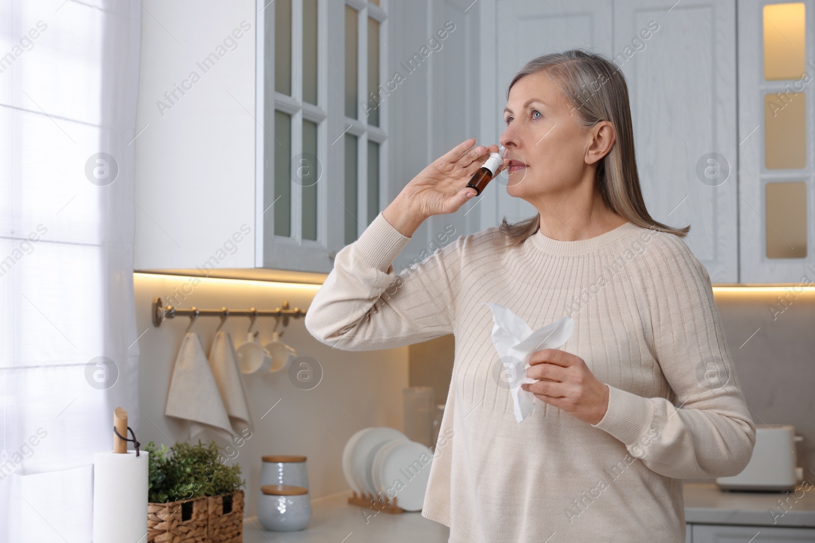 Photo of Medical drops. Woman using nasal spray indoors