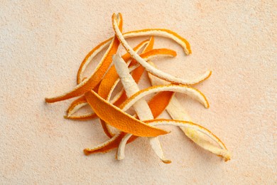 Photo of Dry orange peels on beige table, top view