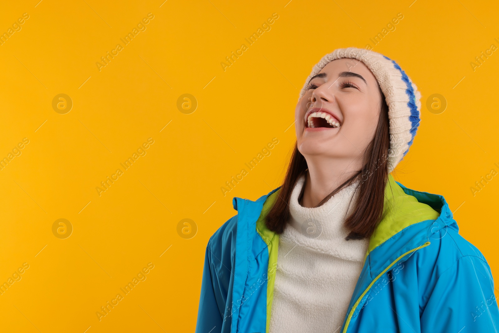 Photo of Beautiful woman laughing on orange background, space for text