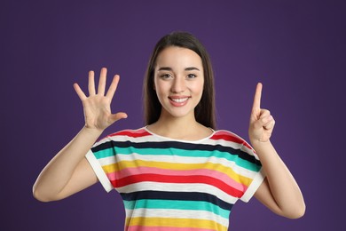 Photo of Woman showing number six with her hands on purple background
