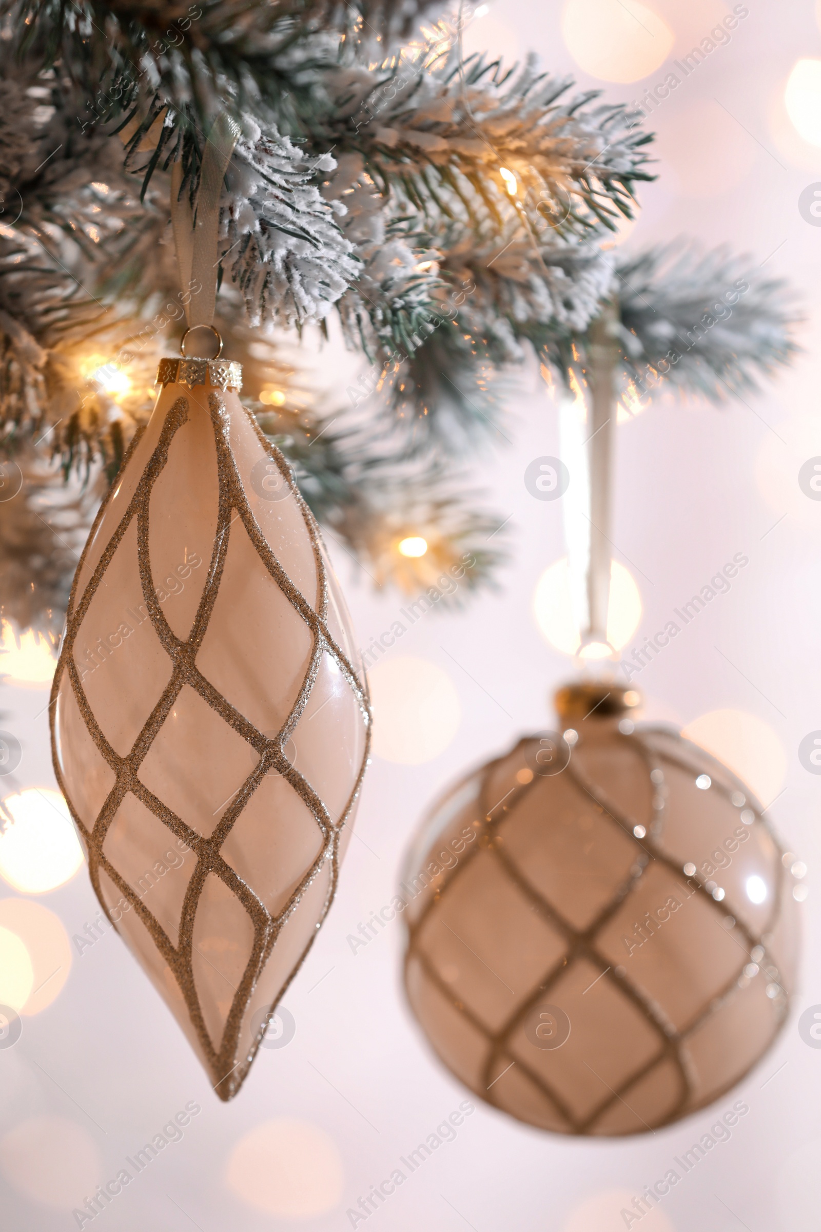 Photo of Christmas tree decorated with holiday baubles against blurred lights, closeup