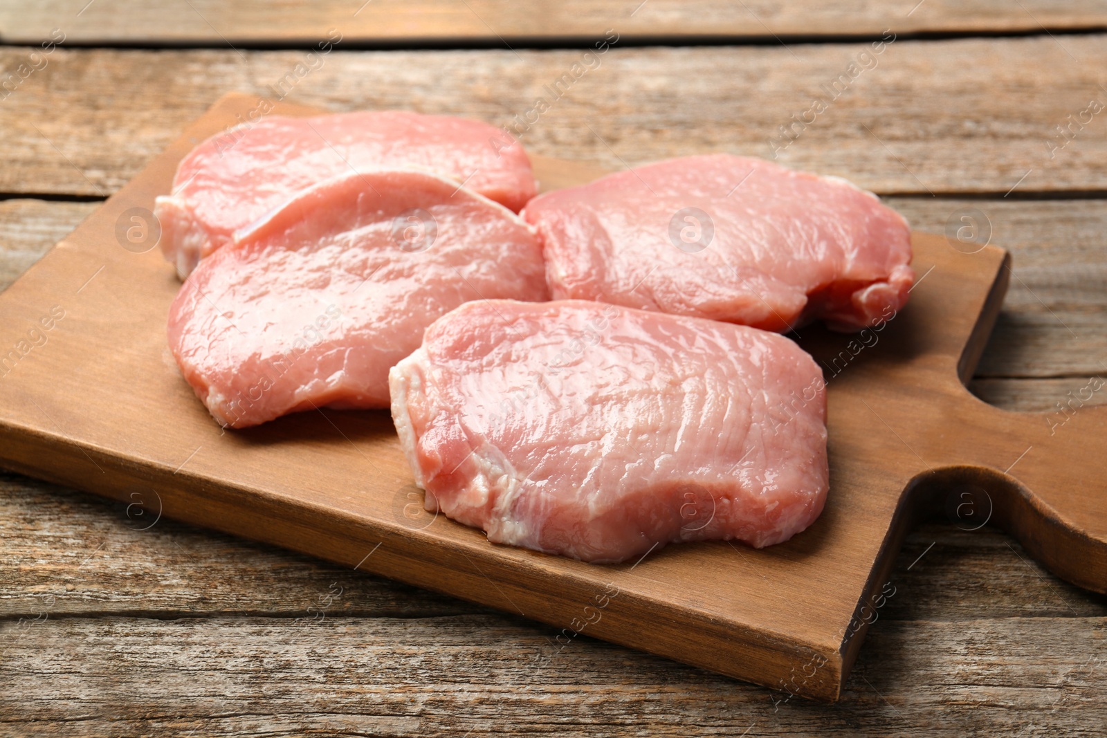 Photo of Pieces of raw pork meat on wooden table