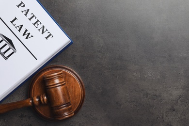 Judge's gavel and Patent Law book on grey background, flat lay. Space for text