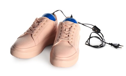 Photo of Pair of stylish shoes with modern electric footwear dryer on white background