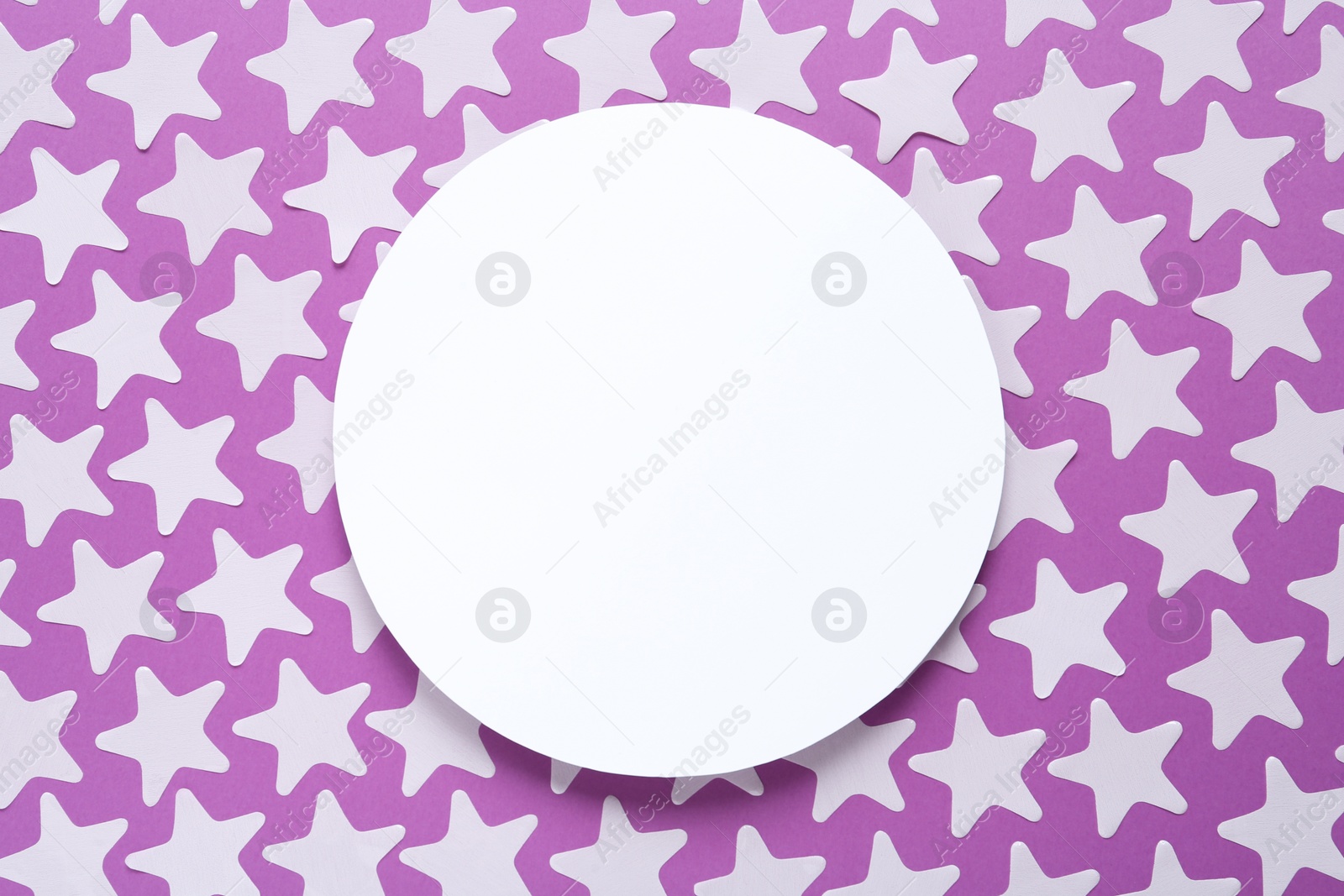 Photo of White star shaped confetti and blank card on violet background, flat lay. Space for text