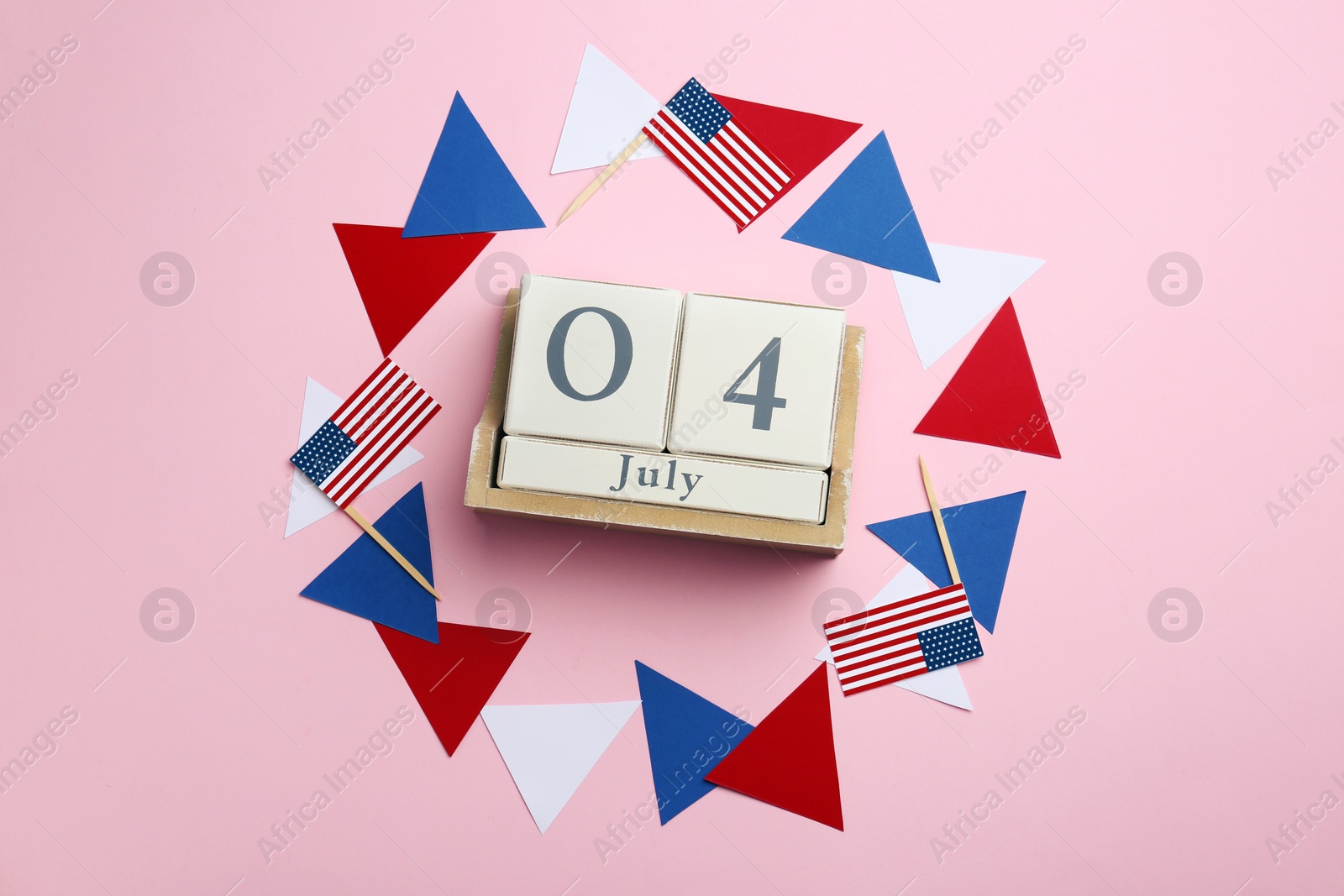 Photo of Flat lay composition with wooden calendar and USA flags on color background. Happy Independence Day