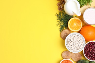 Photo of Food high in calcium. Flat lay composition with different products on yellow background, space for text