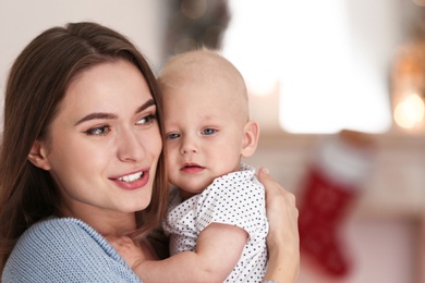 Photo of Happy mother with cute baby at home. Celebrating Christmas