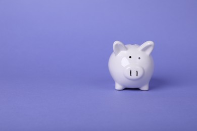 Photo of Ceramic piggy bank on purple background, space for text. Financial savings