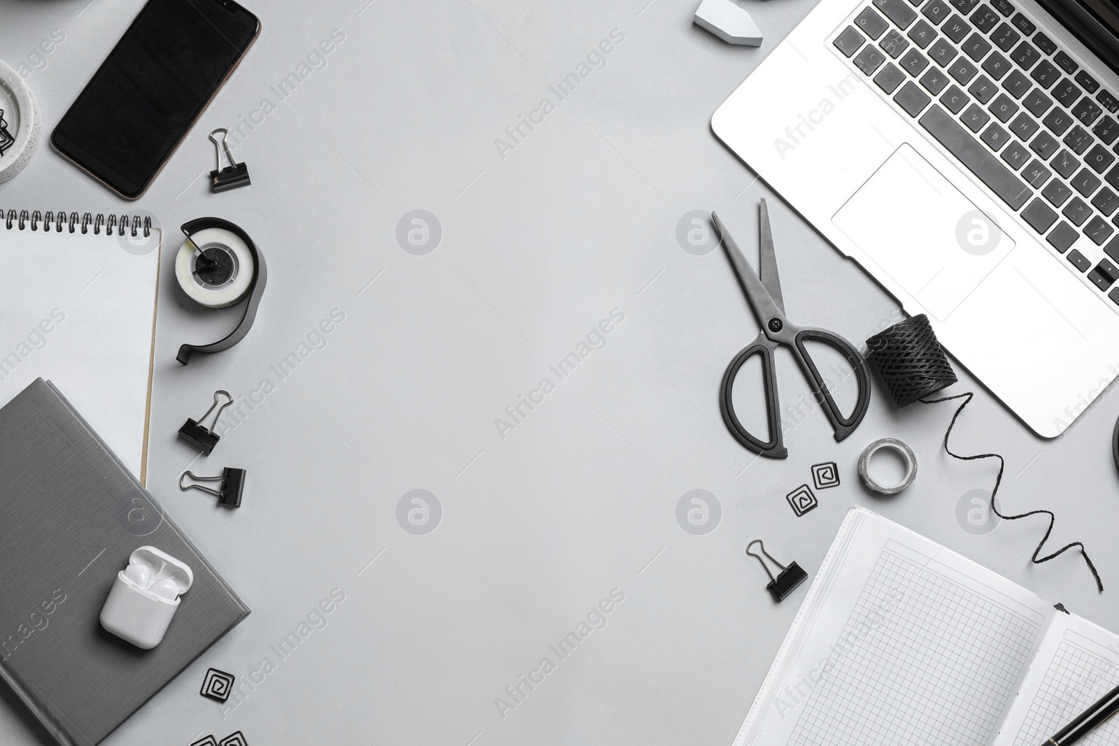 Photo of Flat lay composition with laptop, smartphone and stationery on grey table, space for text. Designer's workplace