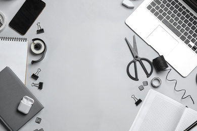 Flat lay composition with laptop, smartphone and stationery on grey table, space for text. Designer's workplace