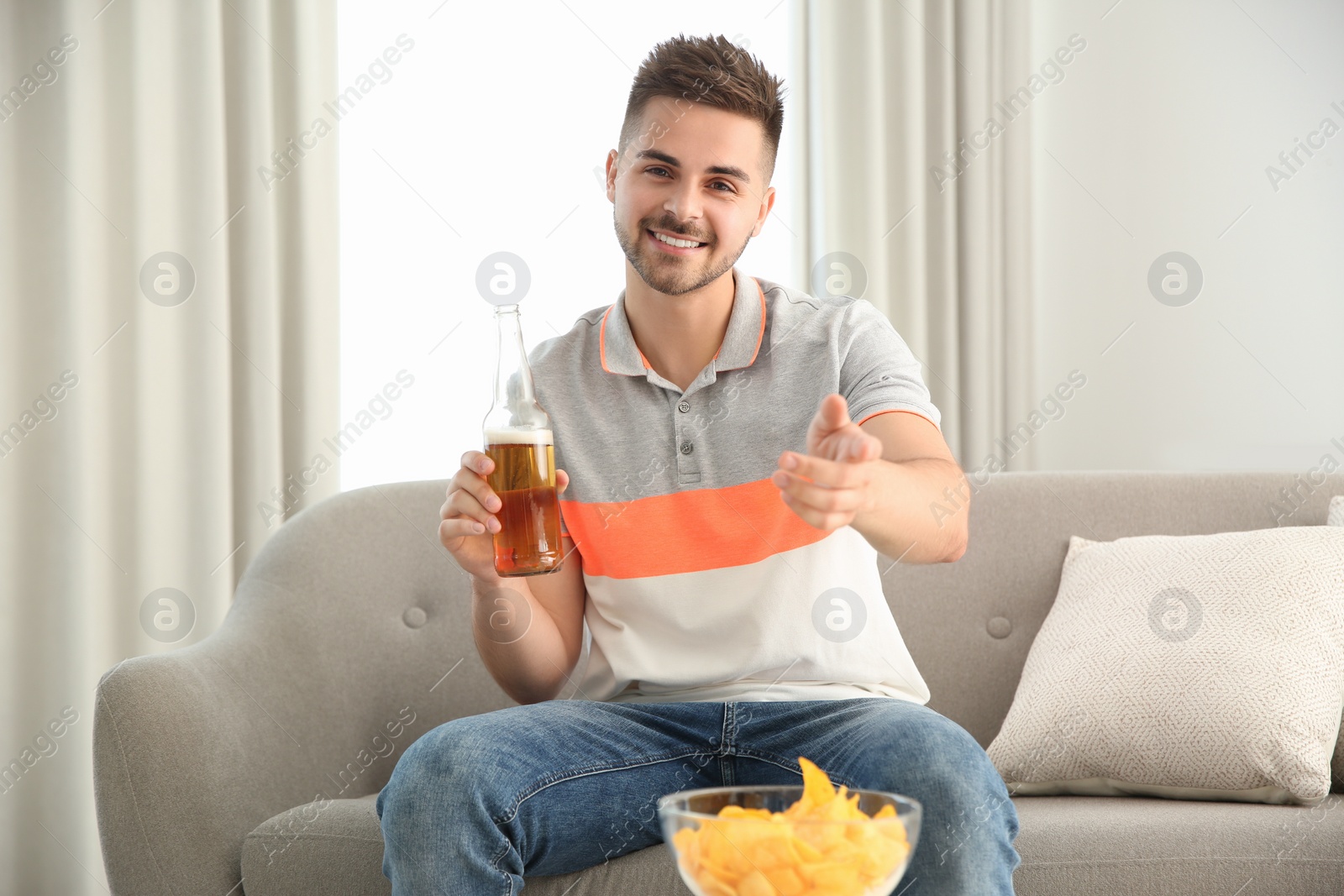 Photo of Man drinking beer while having online video conference at home, view from web camera. Social distancing during coronavirus pandemic