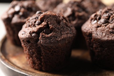 Board with delicious chocolate muffins on table, closeup