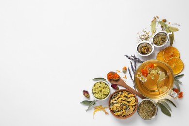 Photo of Freshly brewed tea and dried herbs on white background, top view. Space for text