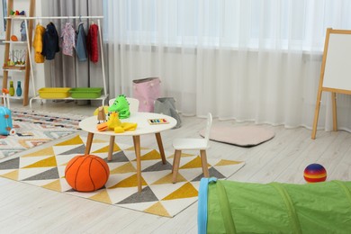 Photo of Child`s playroom with different toys and modern furniture. Stylish kindergarten interior