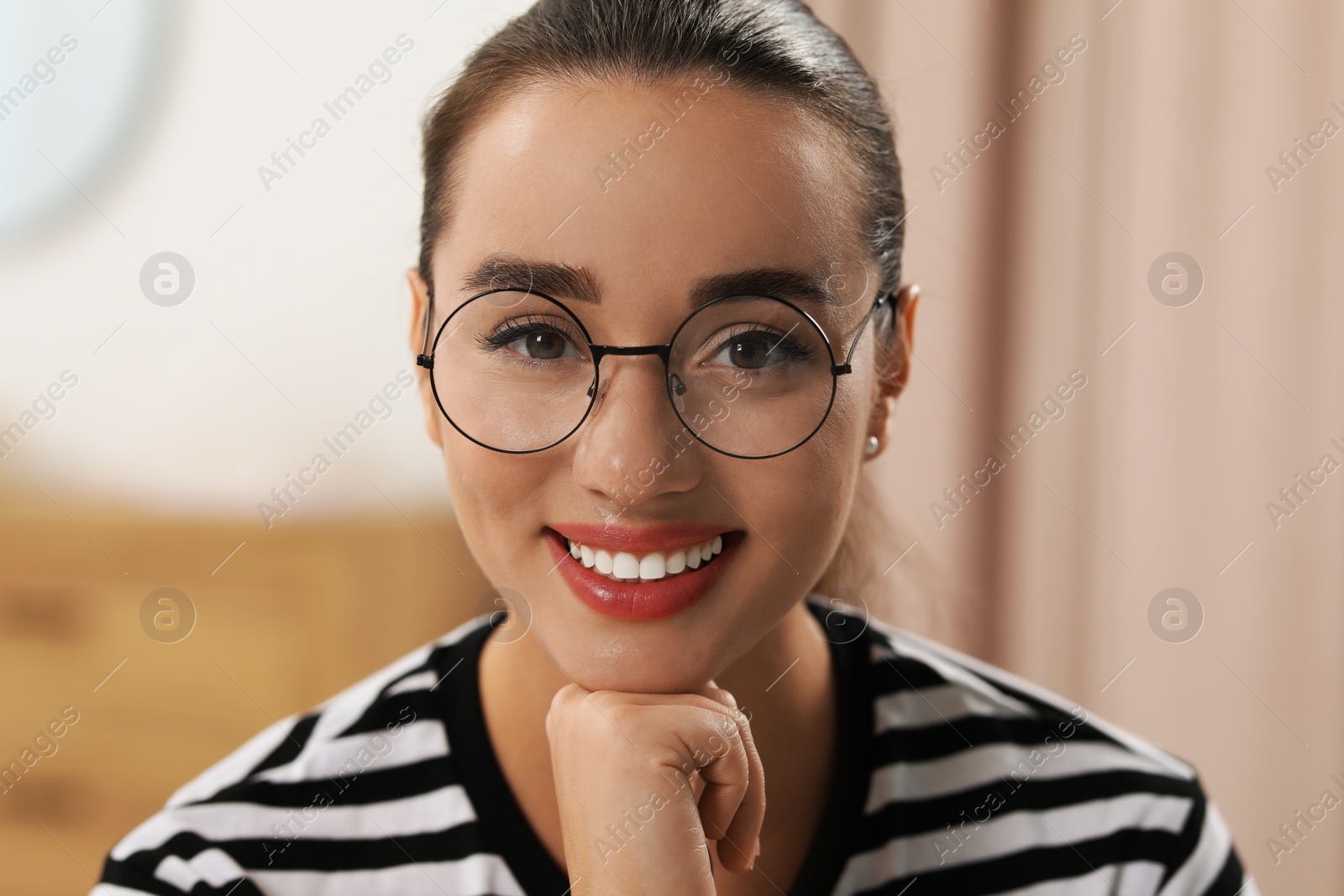 Photo of Portrait of beautiful young woman with glasses indoors. Attractive lady smiling and looking into camera