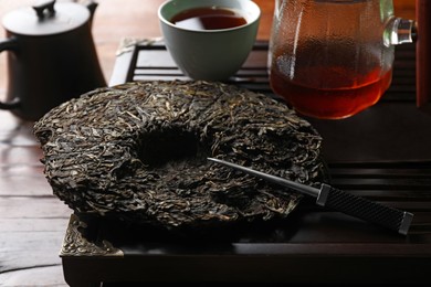 Disc shaped pu-erh tea and knife on table