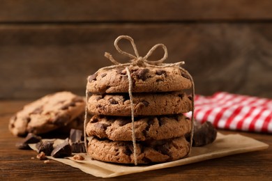 Photo of Many delicious chocolate chip cookies on wooden table