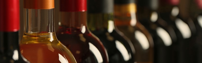 Bottles of different wines, closeup. Banner design