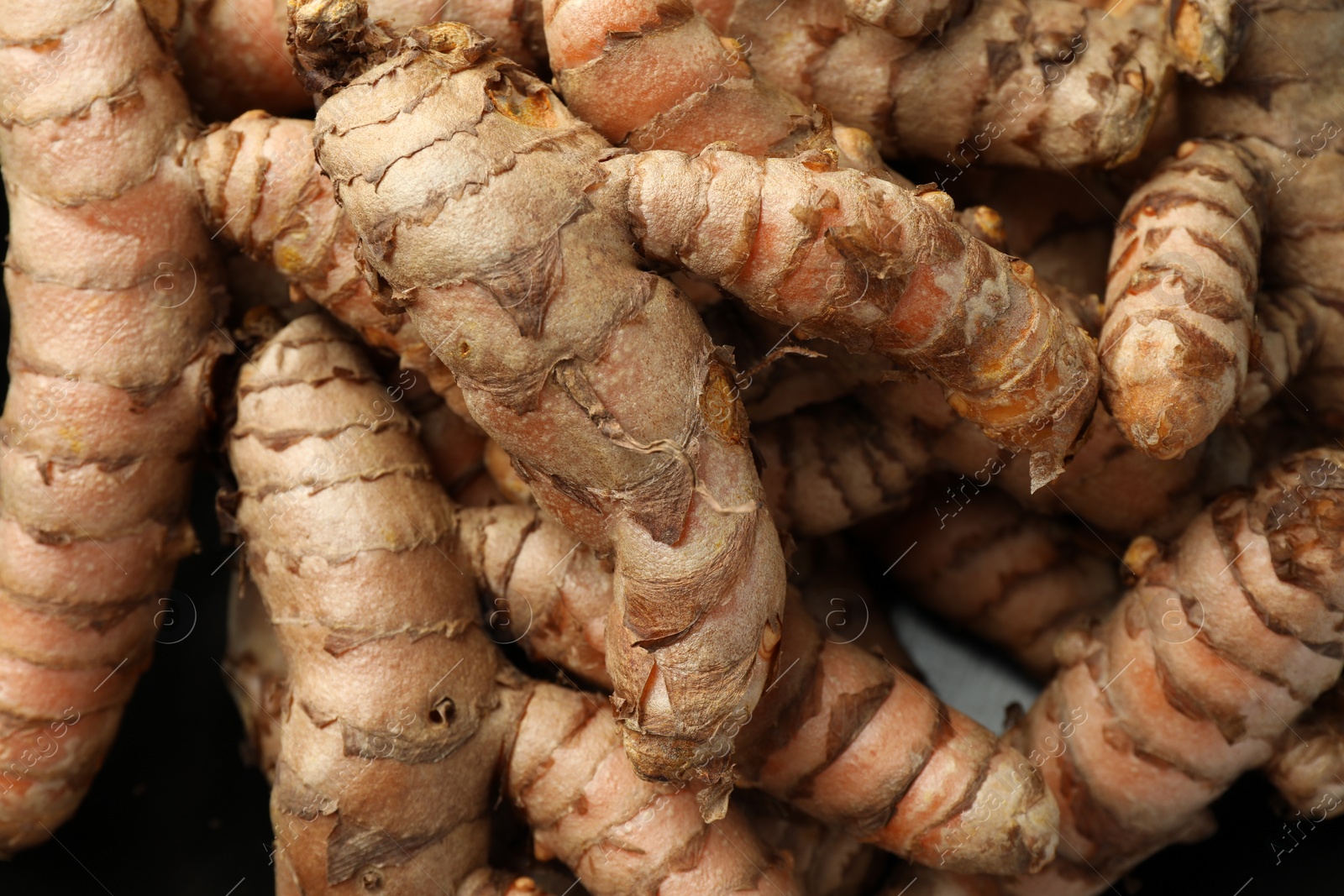 Photo of Many raw turmeric roots as background, top view